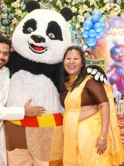 Guests having fun and posing with a panda mascot at the birthday party.