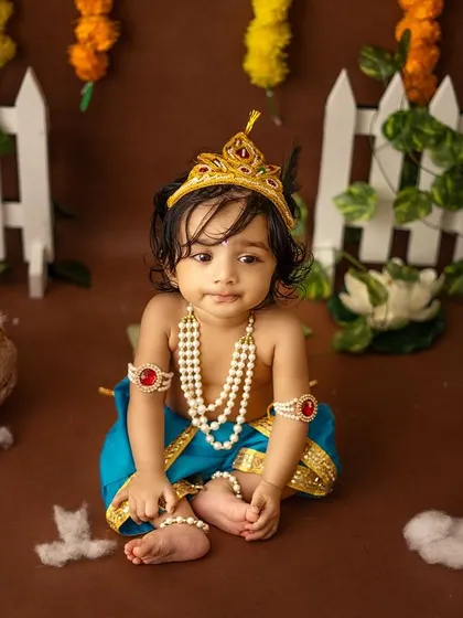 A full view of the adorable baby Krishna in his festive setup.