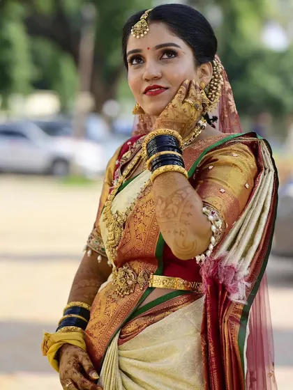 A candid moment with my bride Sahana. Her traditional muhurtham makeup, with its flawless base and classic red lip, looks stunning even in natural outdoor lighting.