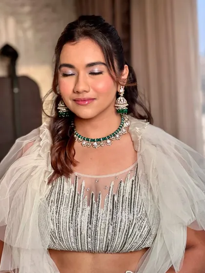 A close-up of this wedding guest's makeup, with her eyes closed to show the shimmering lilac eyeshadow. The look is fresh, modern, and perfect for an engagement party.