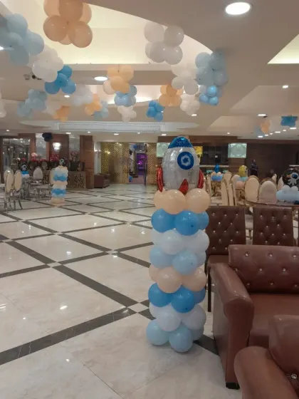 A rocket ship balloon column stands tall in the party hall, adding to the overall space theme and providing a great decorative element.