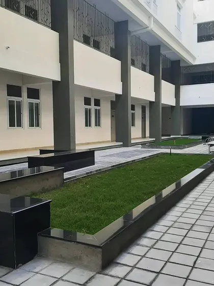 The open courtyard at the St. John's hostel block is designed for relaxation and connection. The clean lines of the planters, the greenery, and the tiled paving create a calm, orderly, and refreshing open space.