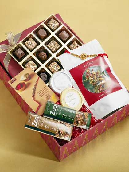 Our red festive hamper brings assorted chocolates, Hot Chocolate Mix, Zeal bars and gift components together with a Rakhi card.