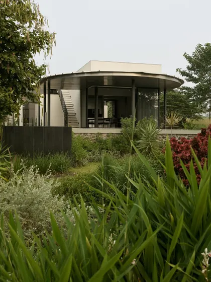 The exterior of Pavilion House, a modern structure of steel and glass set within a wild, natural landscape.