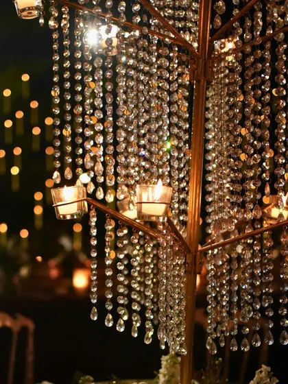 A close-up of the hanging crystal chandelier, with small candles adding to its sparkle.