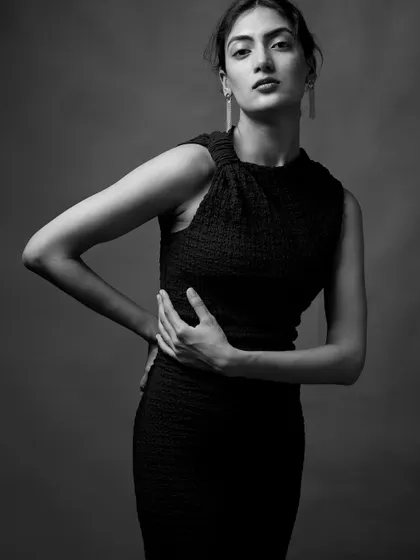 This pose creates a dynamic and powerful silhouette. The interplay of light and shadow on her arms and torso adds depth and dimension to the portrait.