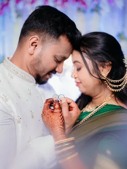 An intimate close-up of the couple holding their rings together. This photo captures the fine details of the rings, the bride's henna, and the tender connection between them.