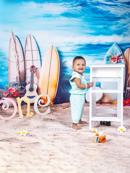 A beach-themed first birthday. This little one is standing tall and proud amidst surfboards and sand, celebrating his milestone with a cool, coastal vibe.