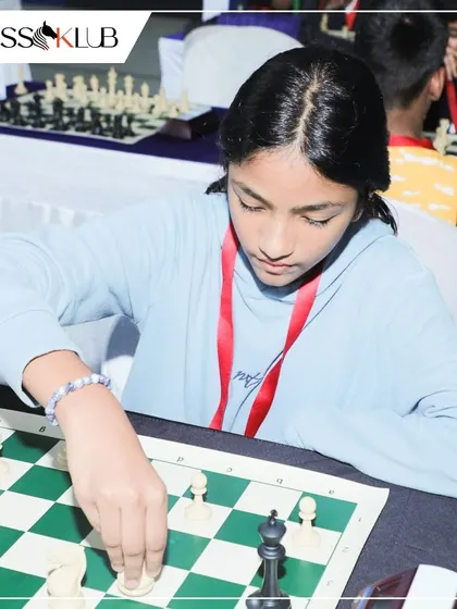 A young girl carefully executes her move in a competitive match, demonstrating the focus and precision we teach.