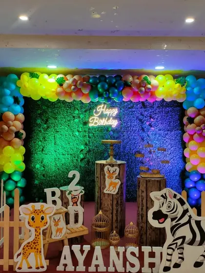 Another angle of the colorful jungle theme, showing the full arrangement with balloon trees and animal cutouts.