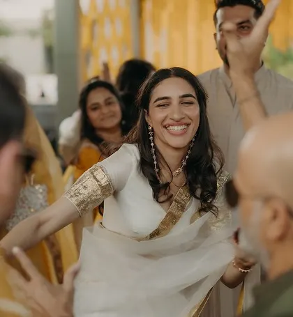 The bride dancing with her family, her lightweight saree allowing for effortless movement and joy.