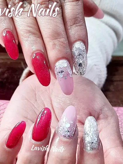 A vibrant set mixing glossy red nails with accent nails featuring a chunky silver glitter fade over a soft pink base.