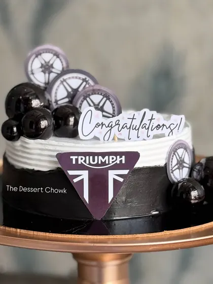 A sleek and modern cake to celebrate buying a new Triumph motorcycle. I used the brand's logo and wheel toppers to create this celebratory design.
