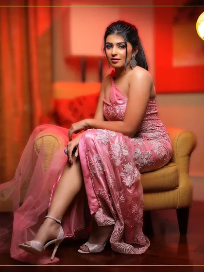 A seated portrait that exudes confidence and glamour. The lighting catches the beautiful shimmer on her skin and the elegant details of the makeup, perfect for an evening event.
