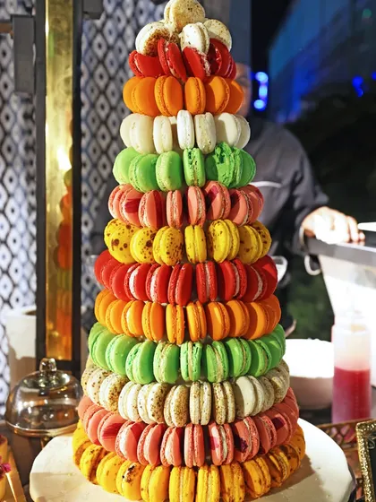 A vibrant, multi-coloured macaron tower stands as a cheerful and delicious centerpiece for a milestone birthday celebration.