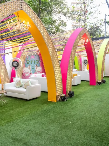 This outdoor lounge area was designed for a vibrant Garba night. We used a series of colorful arches with intricate gold lattice work and ribbon canopies to create semi-private seating zones, combining modern comfort with a festive, traditional atmosphere.