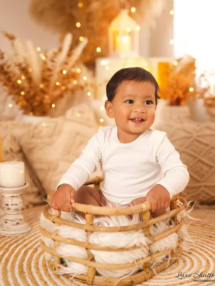 Another joyful shot of this six-month-old, sitting in a wicker basket and smiling brightly. This is a perfect sitter session portrait.