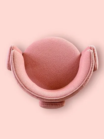 A top-down view of our custom "Pebble" chair in a beautiful coral bouclé fabric. The crisp piping detail and unique shape make it a stunning accent piece for both living rooms and bedrooms.