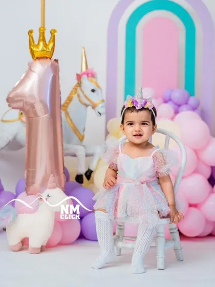 A magical rainbow unicorn theme for a first birthday. The pastel colors, carousel horse, and unicorn props create a dreamy and enchanting atmosphere.