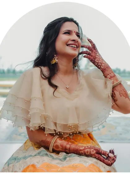 Another happy moment showcasing the bride's beautiful henna and the contemporary design of her cape blouse and colorful lehenga.