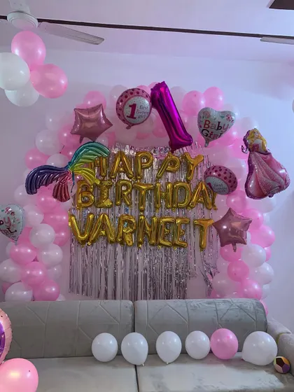 Another view of the princess-themed birthday decor, showing how we can transform a living room into a festive party space using a balloon wall and themed foil balloons.