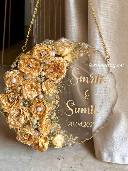 Another angle of a beautiful wall hanging frame made from a preserved varmala. The light catches the golden roses and makes the whole piece shine.