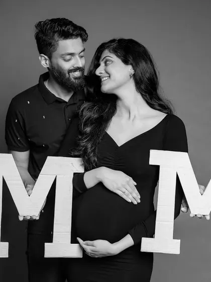 Using "MOM" letter props, this is a fun and clear way to celebrate the mom-to-be in a stylish studio portrait.
