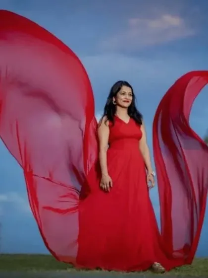 A solo portrait where the red trails of the flying dress look like majestic wings against the sky.