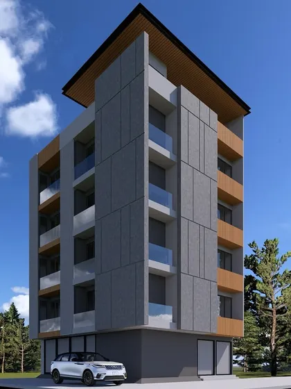 An angled view of the modern apartment building, showing its slender profile and the interplay of different materials against a clear sky. This is urban design focused on sleek, efficient living.
