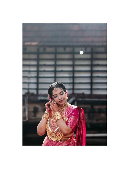 A close-up of the bride adjusting her earring, a classic getting-ready shot.