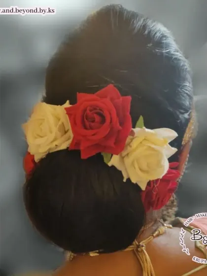 For the mother of the bride, a sleek and clean updo is a wonderfully elegant choice. I styled her hair into a neat bun and adorned it with classic red and white roses for the phera ceremony.