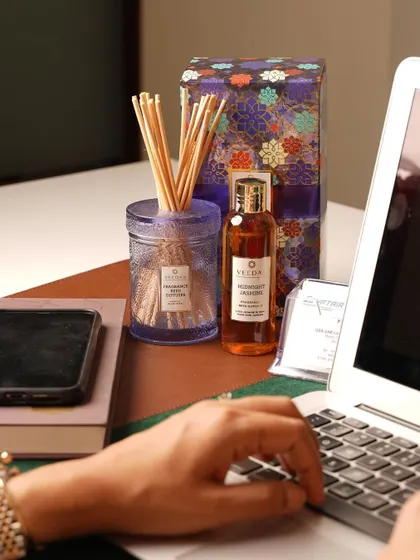 Our reed diffusers are perfect for creating a balanced, continuous fragrance in any room, including your workspace. Here, the Midnight Jasmine diffuser adds a touch of calm to a busy desk.