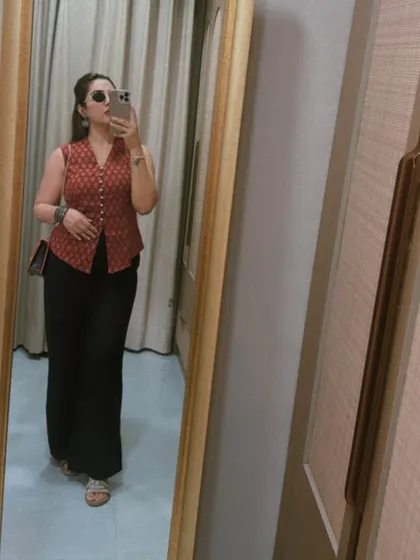 A mirror selfie showing the full silhouette of the red waistcoat and black pants outfit. This combination is a timeless classic, proving that the right pieces can be styled for years to come.