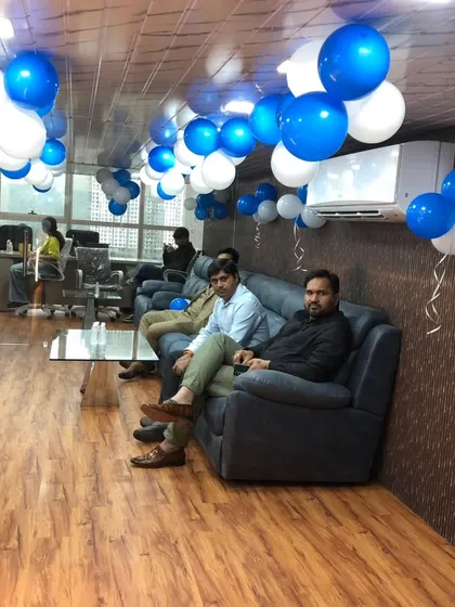 The lounge area of the new office decorated with ceiling balloons, creating a relaxed and celebratory environment for the employees.