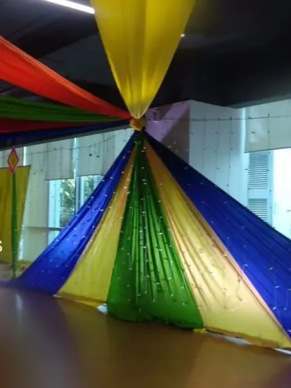For this Dandiya night, we created a spectacular canopy using long, colorful fabric drapes radiating from a central point. This ceiling treatment completely transformed the indoor space, adding energy and a festive atmosphere.