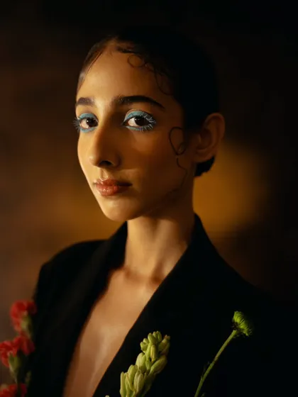 A beauty-focused close-up with creative makeup and delicate lighting. This shot highlights the model's features in an artistic and unconventional way.