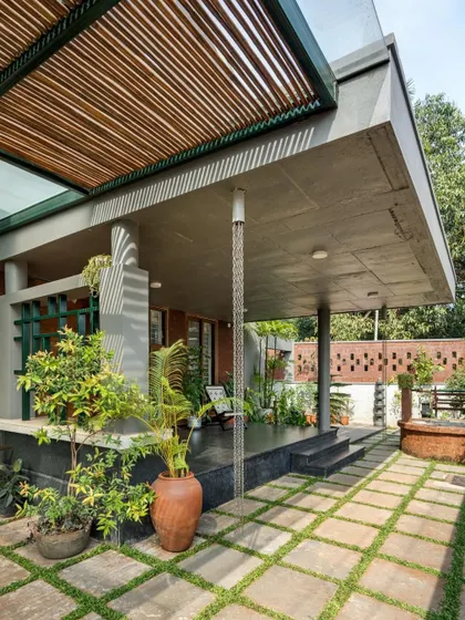 The 'jagali' or verandah is detailed with elements like a rain chain and a traditional well. These small touches connect the design to local culture and the natural elements.