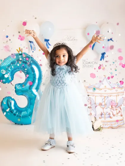 Celebrating with a shower of confetti. The birthday girl throws her hands up in the air with pure joy.