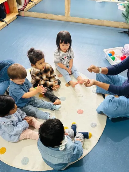 Circle time for our toddlers often includes number rhymes and counting games, introducing numeracy concepts in a playful, social setting.
