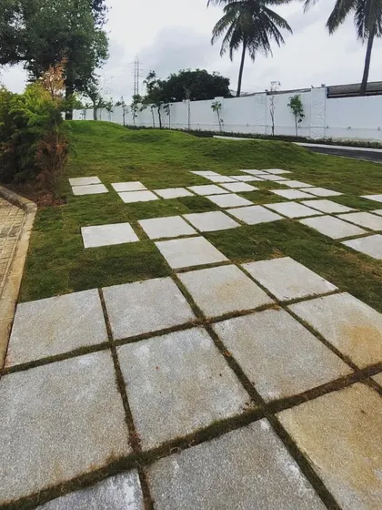 The geometric paving pattern continues across the undulating lawn, creating a dynamic relationship between the hardscape and the softscape. This approach turns a simple lawn into an interactive surface.