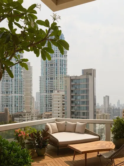 A tranquil spot on the deck, perfect for enjoying the city views. The combination of durable outdoor furniture and lush greenery makes this balcony an extension of the indoor living space.