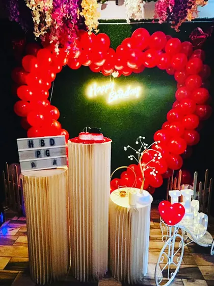 Our 'Green Dream' decor setup, featuring a heart-shaped balloon arch, a neon sign, and a cute bicycle prop. This theme is perfect for a vibrant birthday party.