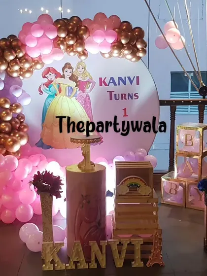 A grand princess party setup with a stunning pink and rose gold balloon arch.