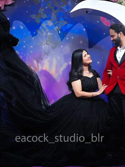 This pre-wedding shoot showcases a dramatic look with a flowing black gown and a sharp red blazer. My indoor studio sets, like this floral one, provide a vibrant and controlled environment for your photos.