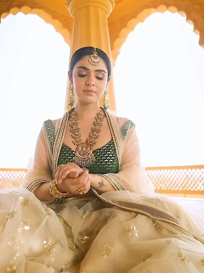 A serene portrait of a bride styled in traditional temple jewellery. The layered necklaces and maang tikka create a complete, regal look, perfect for a South Indian wedding ceremony.