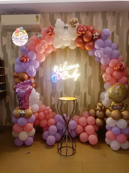 A beautiful 'Welcome Baby' balloon ring in pastel colors with a neon sign, perfect for a photo backdrop.