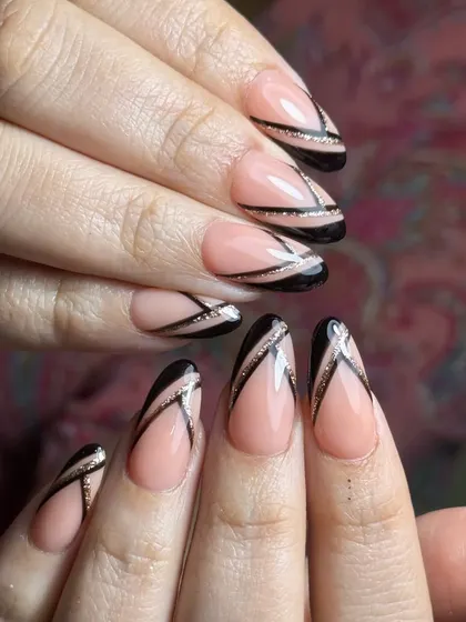 For those who love a modern, graphic look. This design uses a sheer nude base on almond extensions to make the sharp black lines and delicate glitter accents pop.