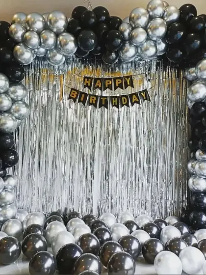 A full arch in black and silver chrome balloons, creating a dramatic photo backdrop.
