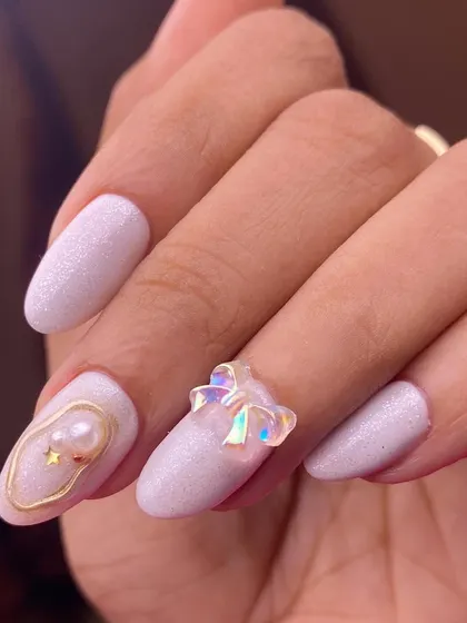 A dreamy and delicate set featuring a pearly white base, iridescent 3D bows, and subtle gold accents with pearls. This design is perfect for anyone looking for a touch of ethereal magic.