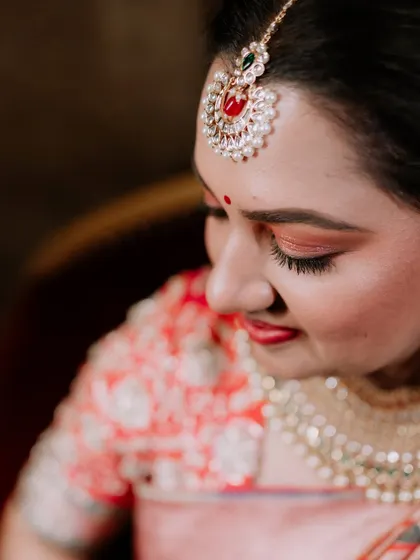 Duplicate of image 62, a close-up of the bride's makeup and jewelry.